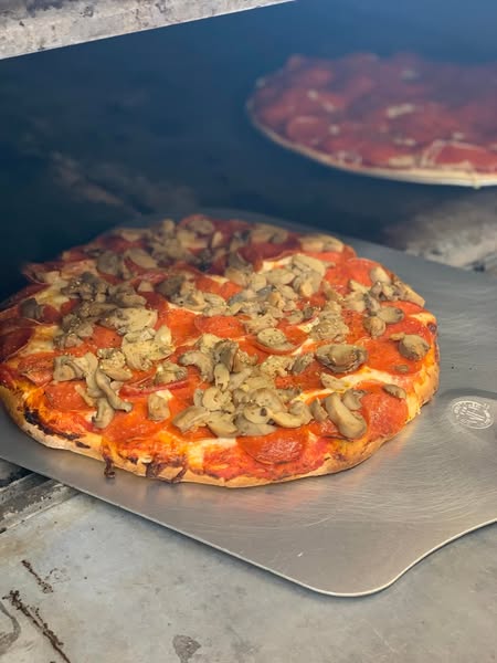 Pepperoni and mushroom pizza baking in oven