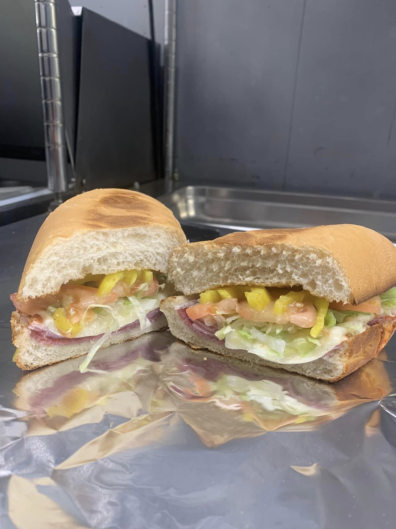 Italian sub sandwich with lettuce, tomato, and banana peppers
